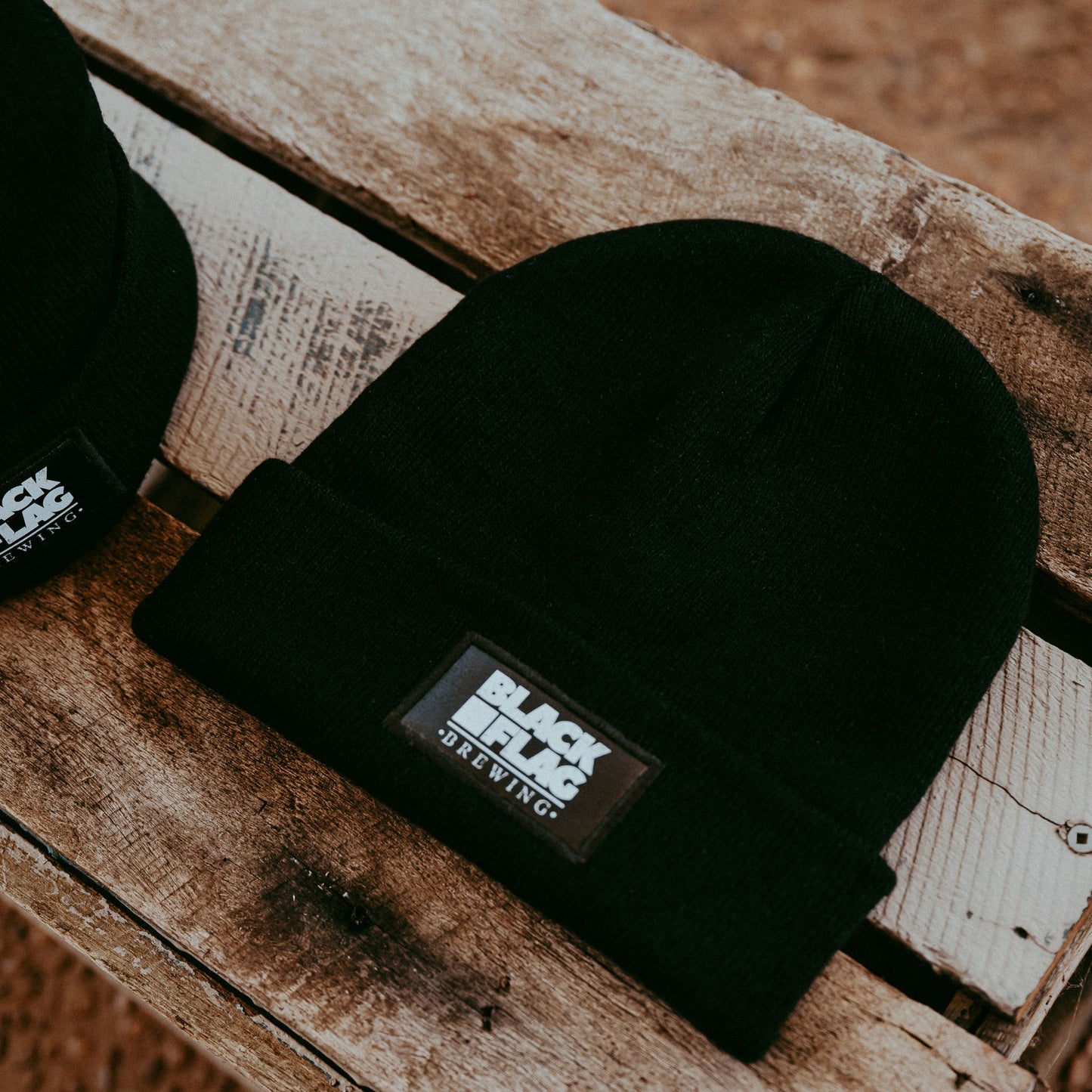 Black woollen beanie with small Blackflag Brewing logo badge stitched on front.