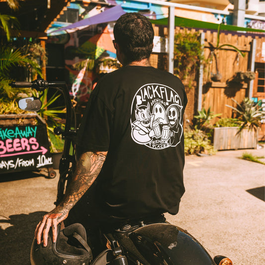 Man on motorcycle wearing a black Blackflag t-shirt with hand drawn Friends In Low Places illustration on back.