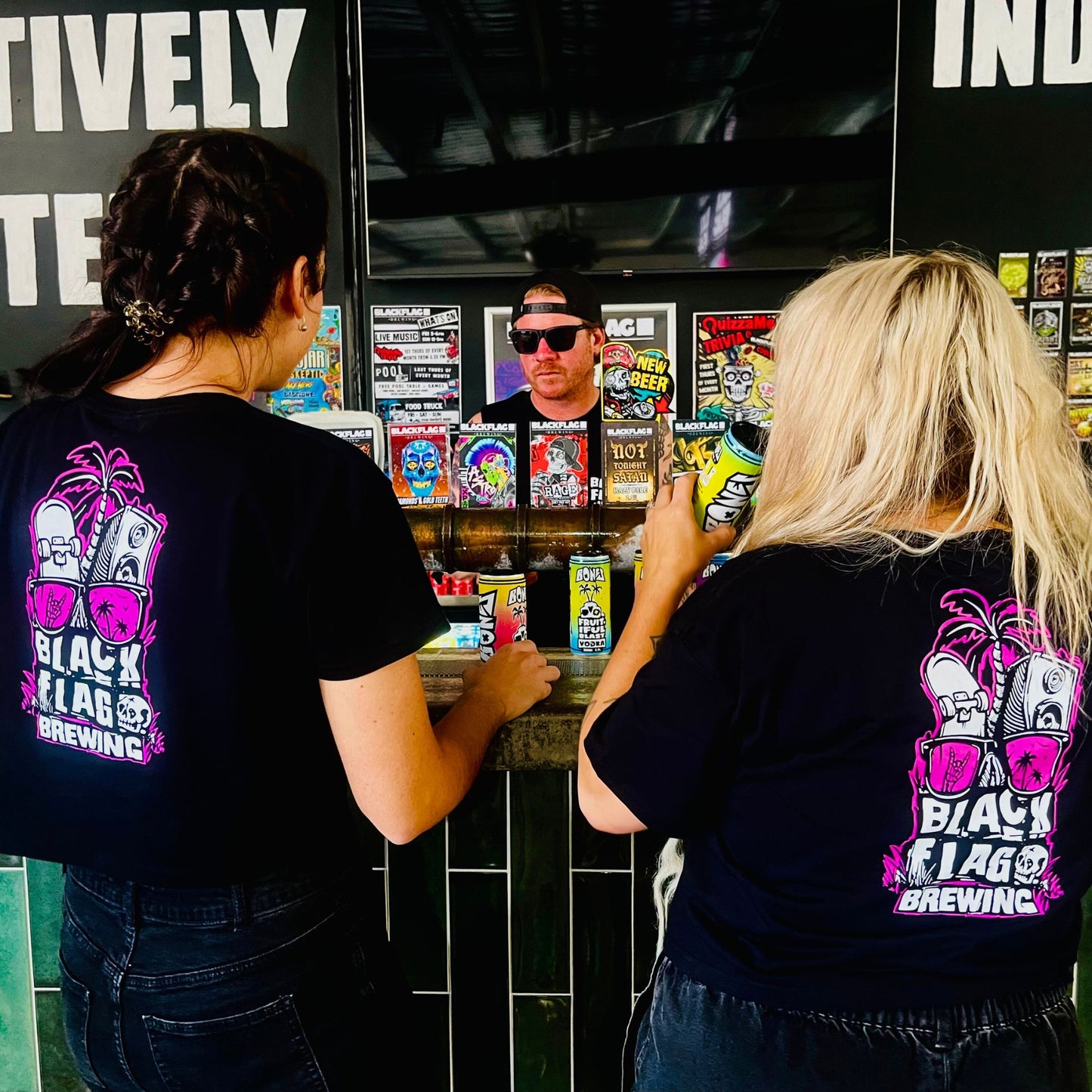 Women wearing a black Blackflag crop tee with hand drawn Shady Palms illustration on back.