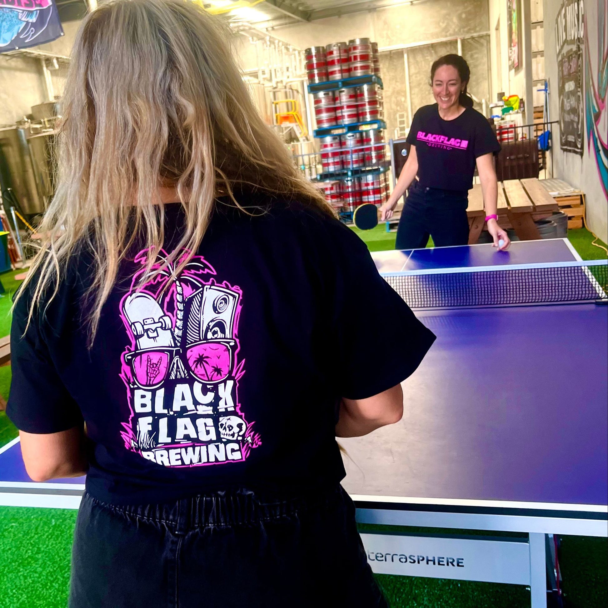 Women wearing a black Blackflag crop tee with hand drawn Shady Palms illustration on back.