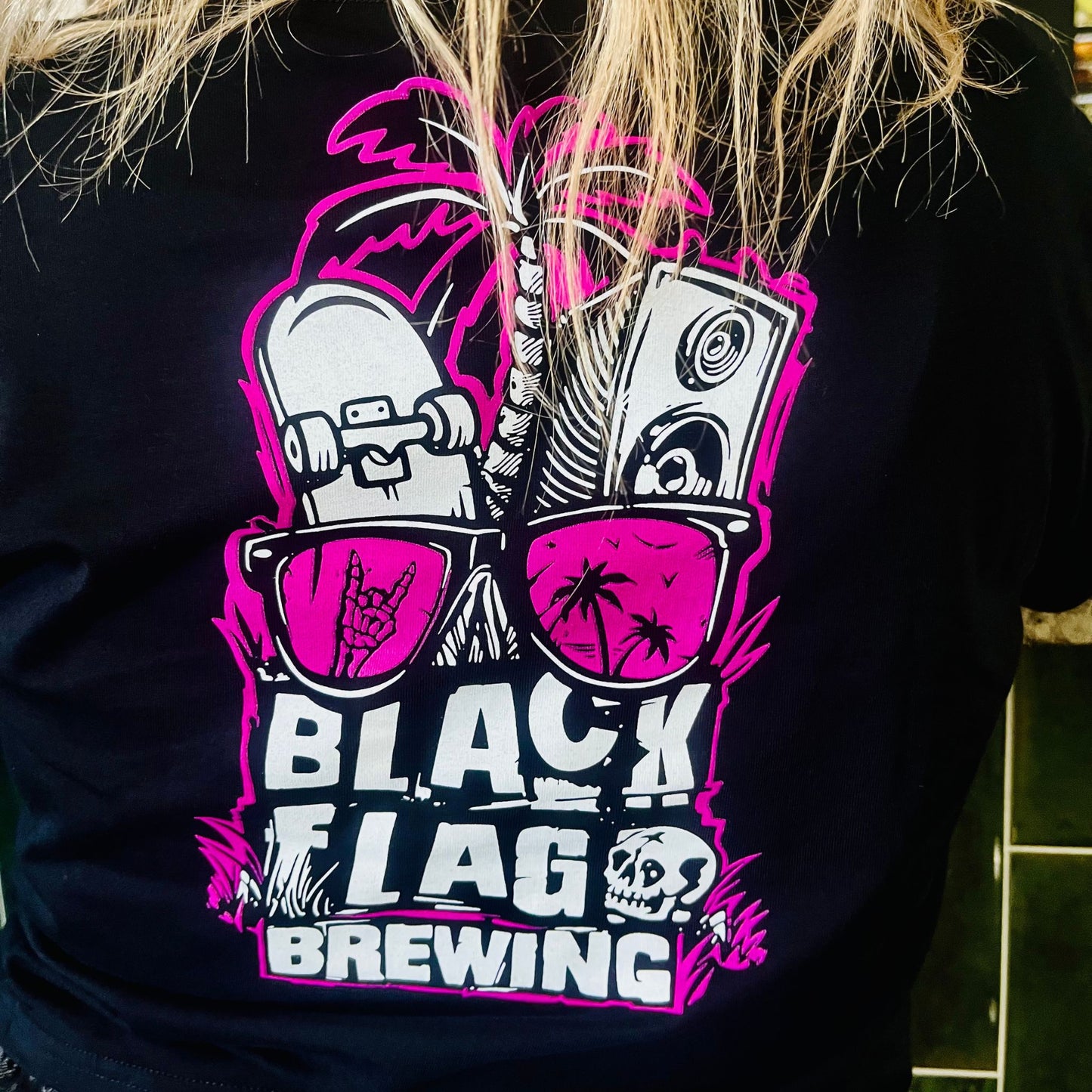 Woman wearing a black Blackflag crop tee with hand drawn Shady Palms illustration on back.